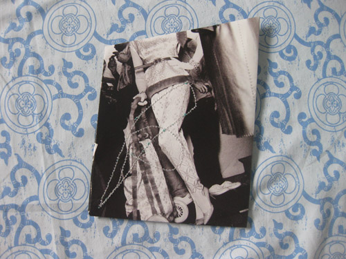 A draped lace figure in black and white, dense beaded stitching worked down the centre
