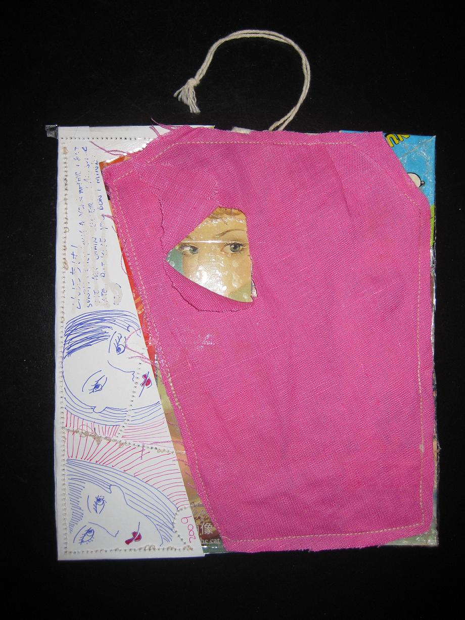 A pink fabric panel stitched over pale cloth, one small cut-out face showing through a gap
